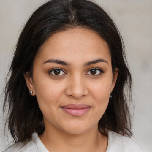 Joyful latino young-adult female with medium  brown hair and brown eyes