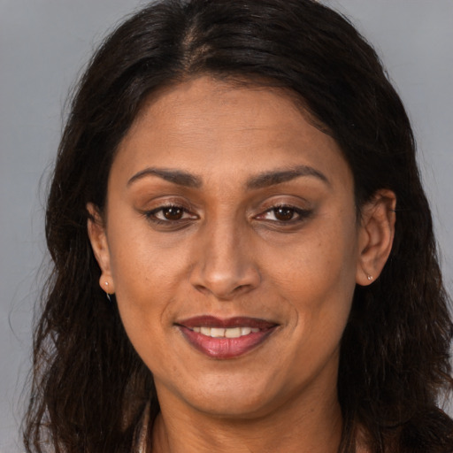 Joyful latino adult female with long  brown hair and brown eyes
