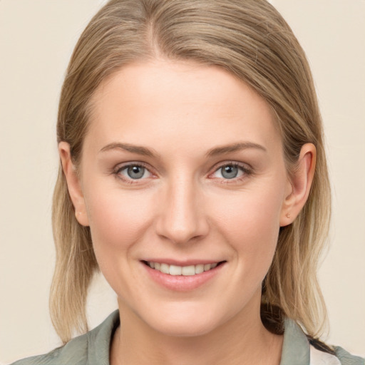 Joyful white young-adult female with medium  brown hair and green eyes