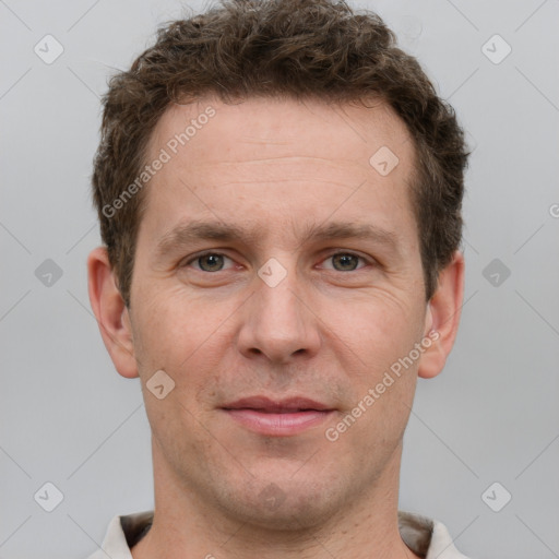 Joyful white adult male with short  brown hair and grey eyes