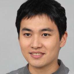 Joyful asian young-adult male with short  black hair and brown eyes