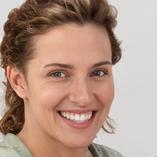 Joyful white young-adult female with medium  brown hair and blue eyes