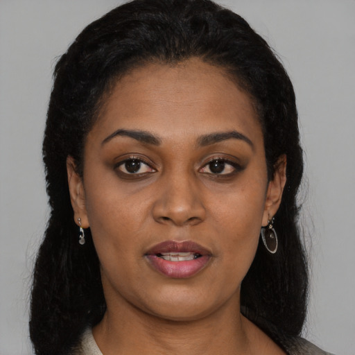 Joyful black young-adult female with long  black hair and brown eyes