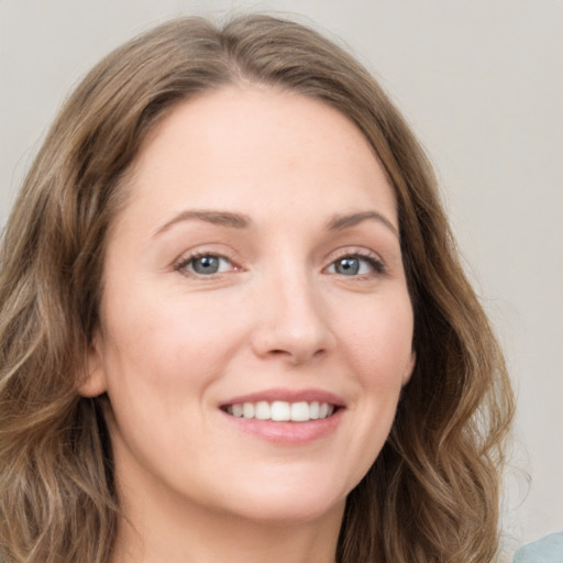 Joyful white young-adult female with long  brown hair and green eyes