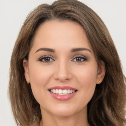 Joyful white young-adult female with long  brown hair and brown eyes