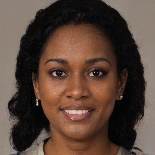 Joyful black young-adult female with long  black hair and brown eyes