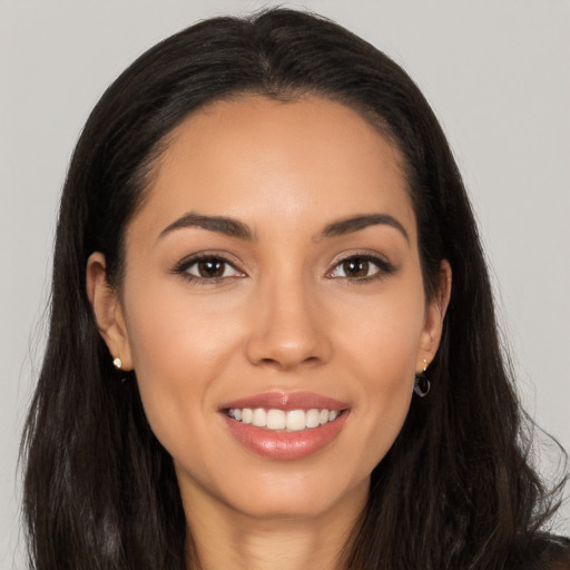 Joyful latino young-adult female with long  brown hair and brown eyes