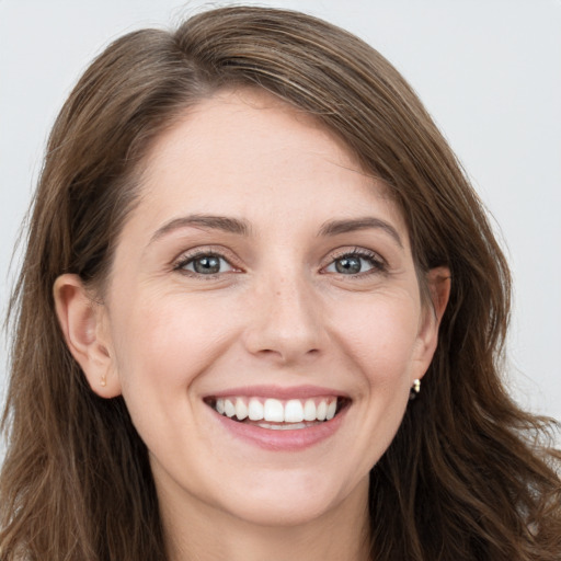 Joyful white young-adult female with long  brown hair and grey eyes