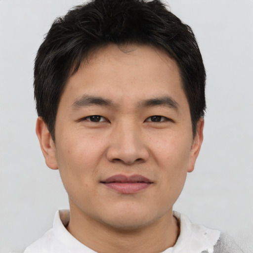 Joyful asian young-adult male with short  brown hair and brown eyes