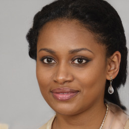 Joyful black young-adult female with long  brown hair and brown eyes