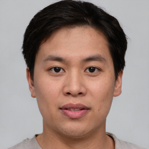 Joyful asian young-adult male with short  brown hair and brown eyes