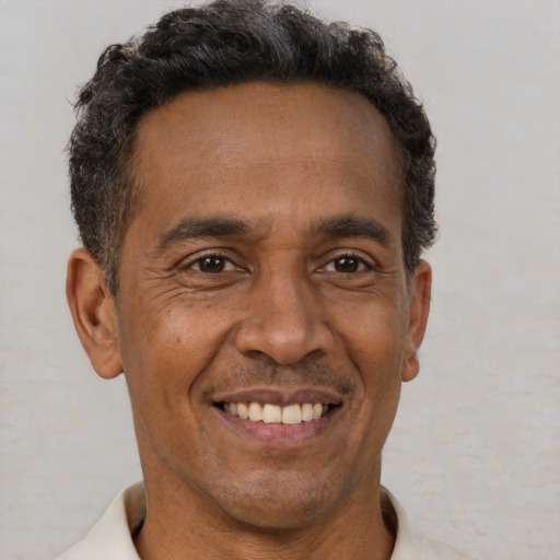 Joyful black adult male with short  brown hair and brown eyes