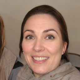 Joyful white adult female with long  brown hair and grey eyes