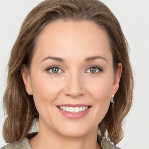 Joyful white young-adult female with medium  brown hair and green eyes