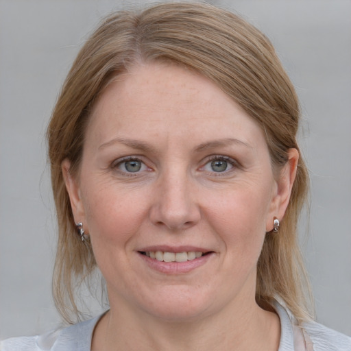 Joyful white adult female with medium  brown hair and blue eyes