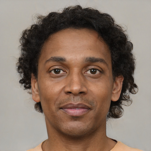 Joyful black adult male with short  brown hair and brown eyes