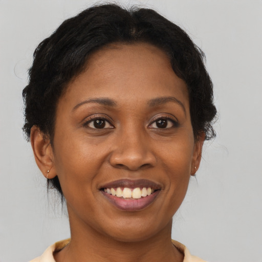 Joyful black adult female with medium  brown hair and brown eyes
