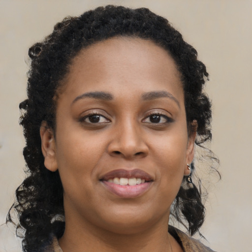 Joyful black young-adult female with long  brown hair and brown eyes