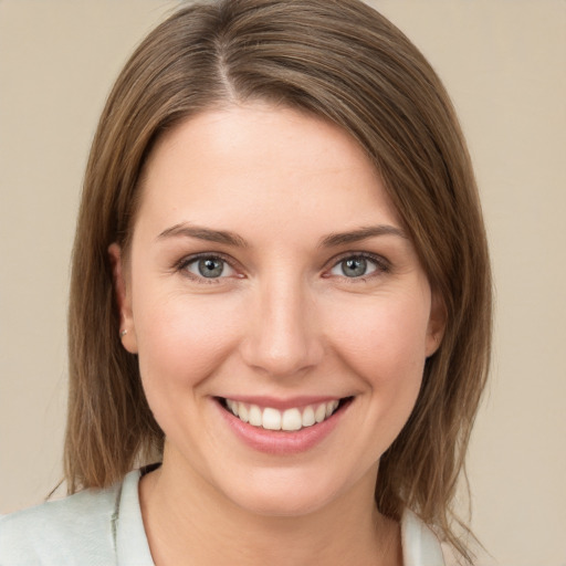 Joyful white young-adult female with medium  brown hair and green eyes