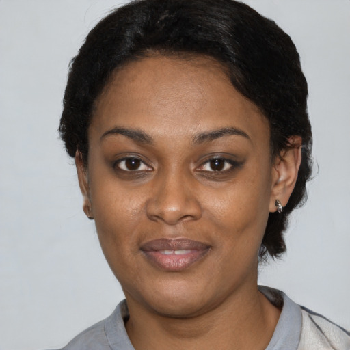 Joyful black young-adult female with short  black hair and brown eyes