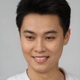 Joyful asian young-adult male with short  brown hair and brown eyes