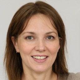 Joyful white adult female with medium  brown hair and grey eyes