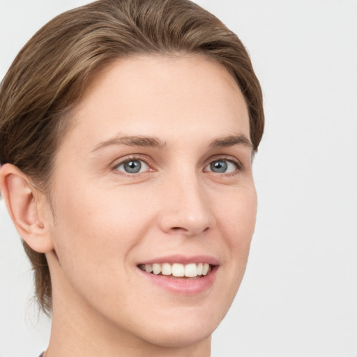 Joyful white young-adult female with short  brown hair and grey eyes