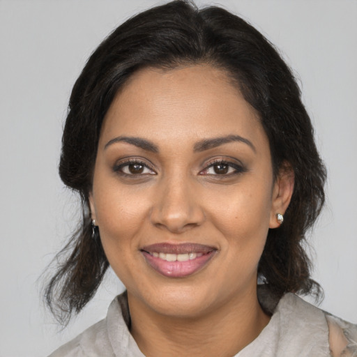 Joyful black young-adult female with medium  brown hair and brown eyes