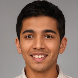 Joyful latino young-adult male with short  brown hair and brown eyes