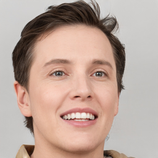 Joyful white young-adult male with medium  brown hair and grey eyes