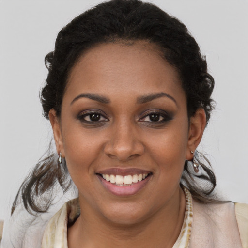 Joyful black young-adult female with long  brown hair and brown eyes