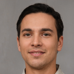 Joyful white young-adult male with short  black hair and brown eyes