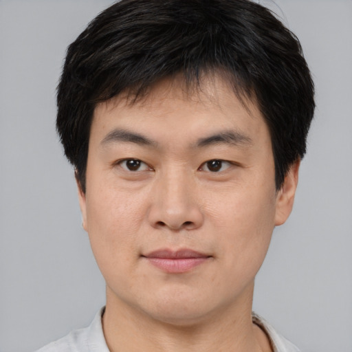 Joyful asian young-adult male with short  brown hair and brown eyes
