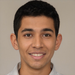 Joyful latino young-adult male with short  black hair and brown eyes