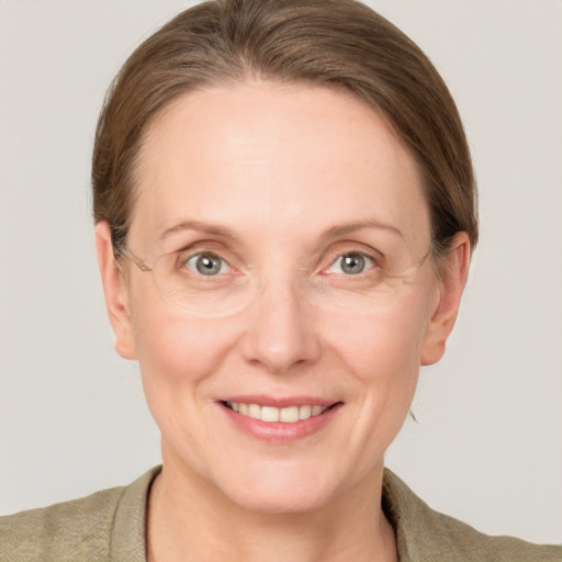 Joyful white adult female with medium  brown hair and grey eyes