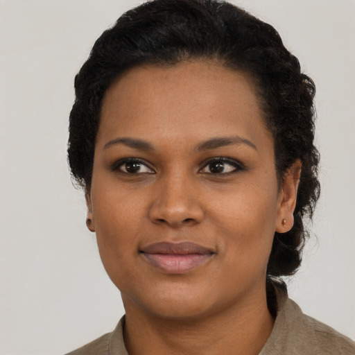 Joyful black young-adult female with short  black hair and brown eyes