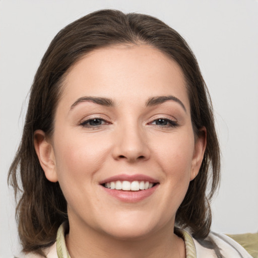 Joyful white young-adult female with medium  brown hair and grey eyes