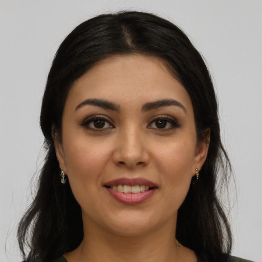 Joyful latino young-adult female with long  brown hair and brown eyes