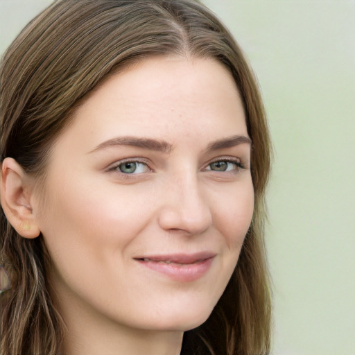 Joyful white young-adult female with long  brown hair and blue eyes