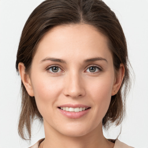 Joyful white young-adult female with medium  brown hair and grey eyes