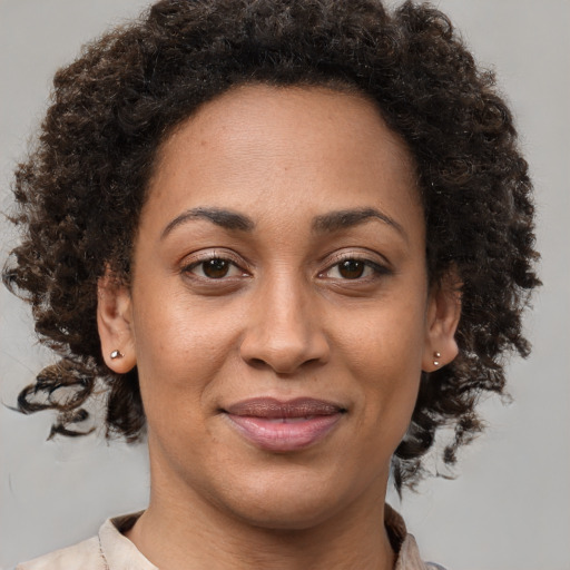 Joyful black adult female with medium  brown hair and brown eyes
