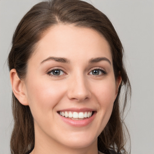 Joyful white young-adult female with long  brown hair and grey eyes