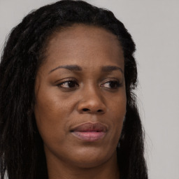 Joyful black young-adult female with long  brown hair and brown eyes