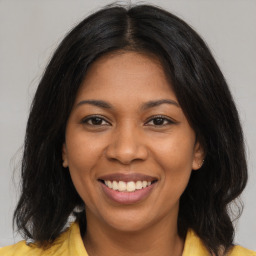 Joyful black young-adult female with long  brown hair and brown eyes