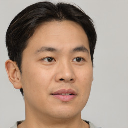 Joyful asian young-adult male with short  brown hair and brown eyes