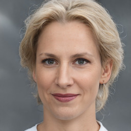 Joyful white adult female with medium  brown hair and grey eyes