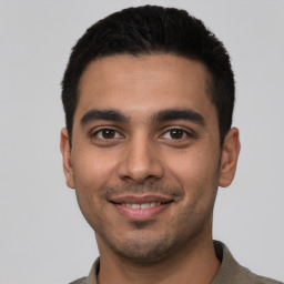 Joyful latino young-adult male with short  black hair and brown eyes