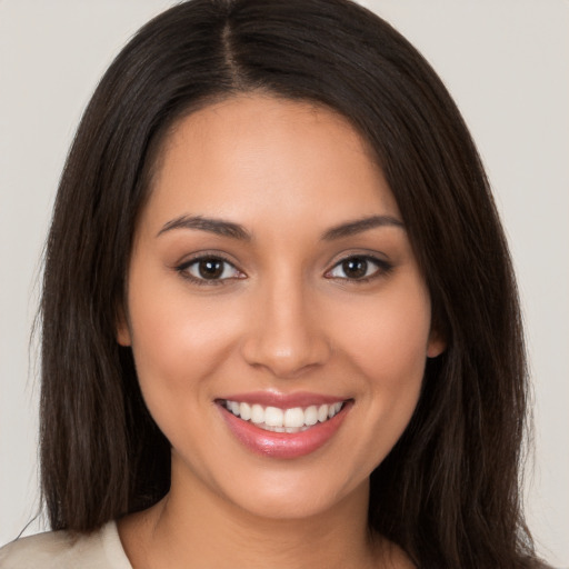 Joyful white young-adult female with long  brown hair and brown eyes