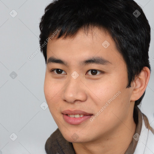 Joyful asian young-adult male with short  black hair and brown eyes