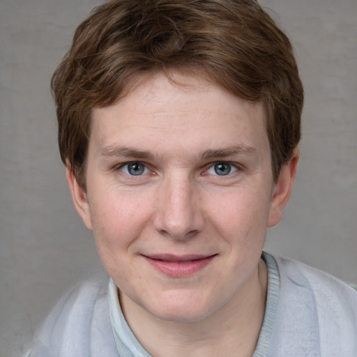 Joyful white young-adult male with short  brown hair and blue eyes